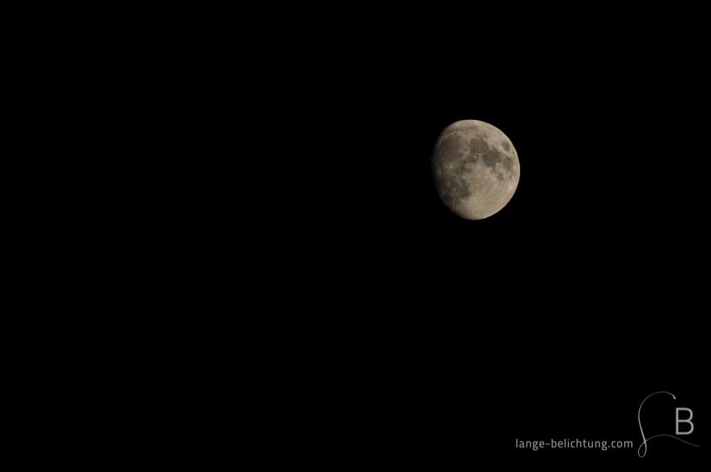 Zunehmender Mond in tiefschwarzer Nacht.